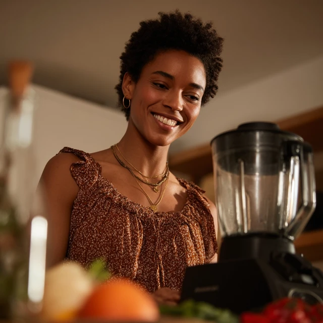 Cheerful Woman Using Blender in Kitchen Lifestyle Photo