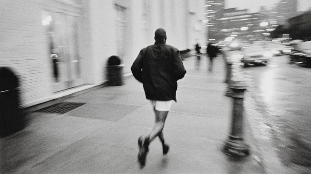 Man Running Down Street Black and White Photography