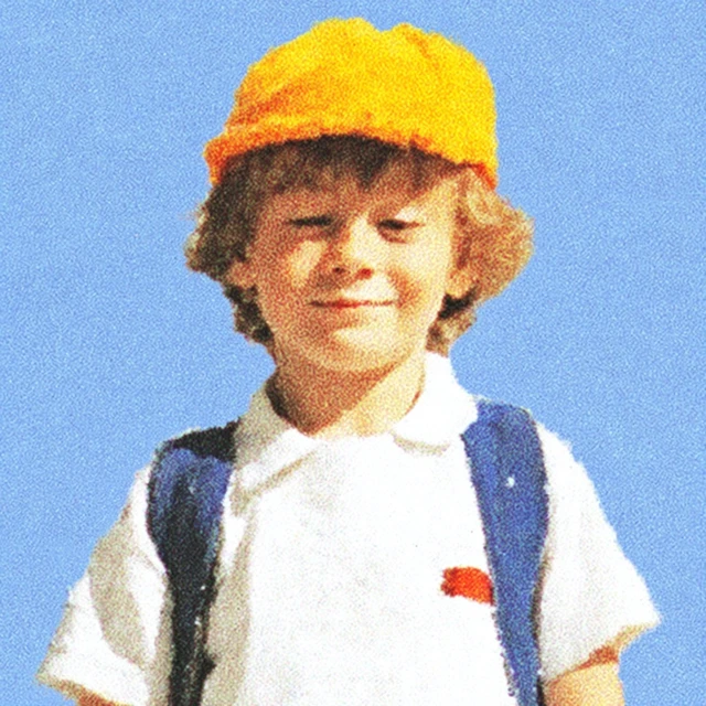 Child in School Uniform with Yellow Hat and Backpack