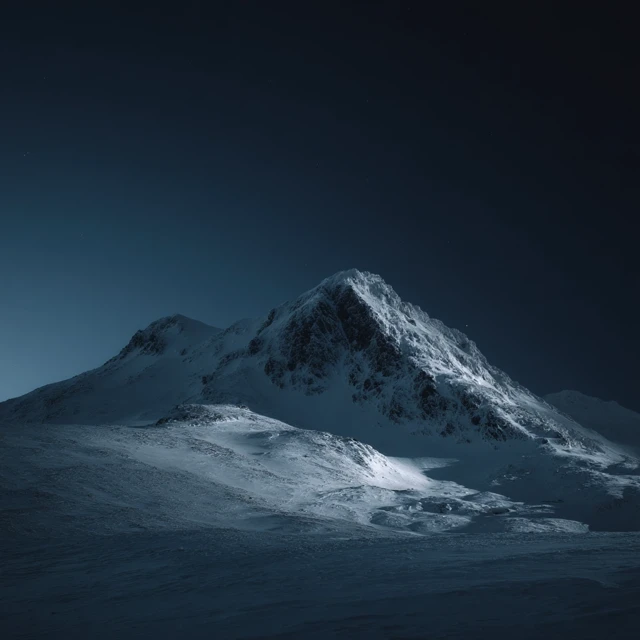 Snowy Mountain Peak Under a Dark Sky