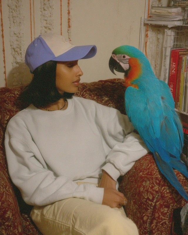 Woman in Cap with Parrot iPhone 14 Photo