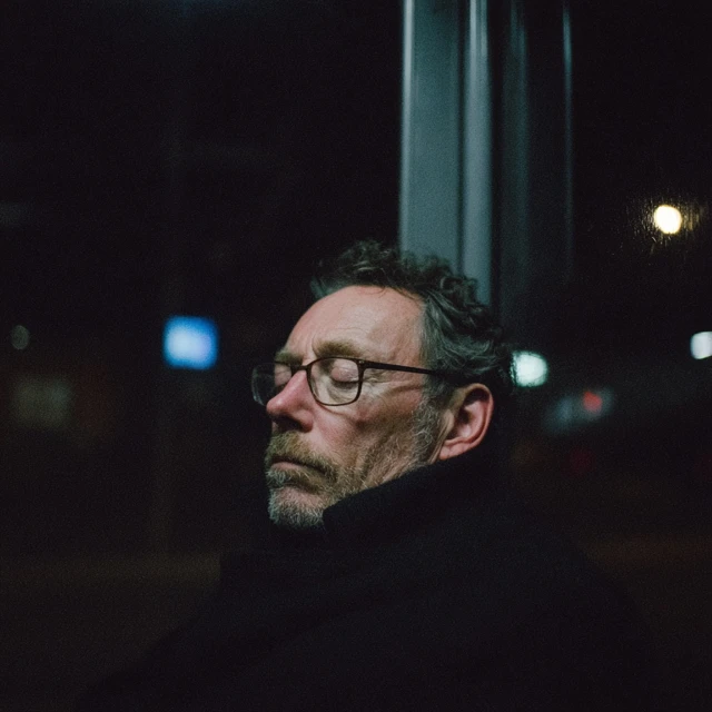 Man at Bus Stop Deep in Thought at Night