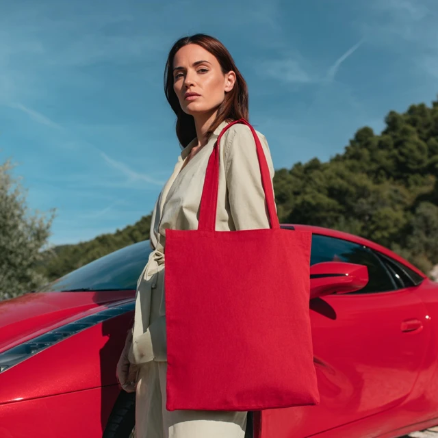 Stylish Woman with Tote Bag by Red Sports Car