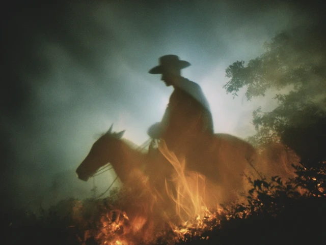 Cowboy Silhouette Riding Horse at Night Photograph