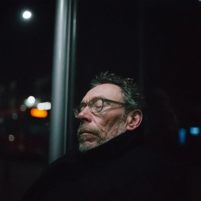 Man at Bus Stop Deep in Thought at Night