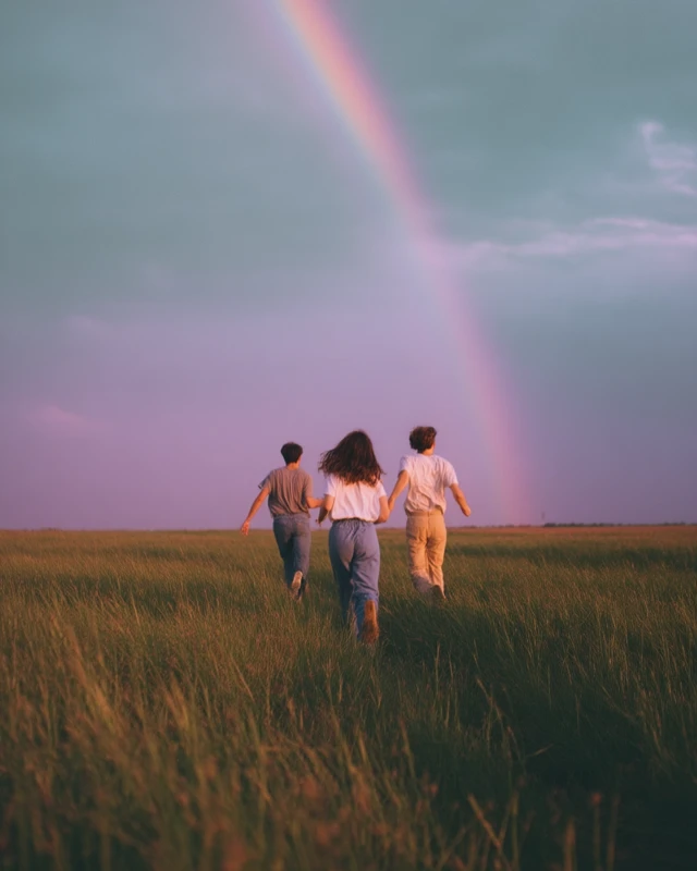 Friends Chasing Rainbow Across a Field