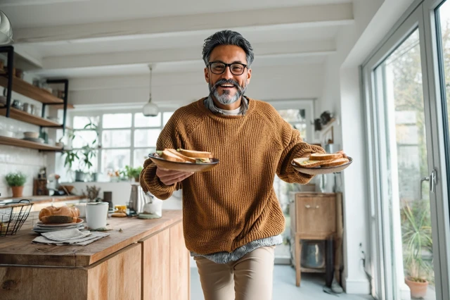 Cheerful Man Dancing with Breakfast in Kitchen