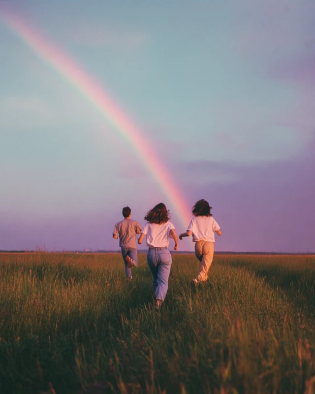 Friends Chasing Rainbow Across a Field