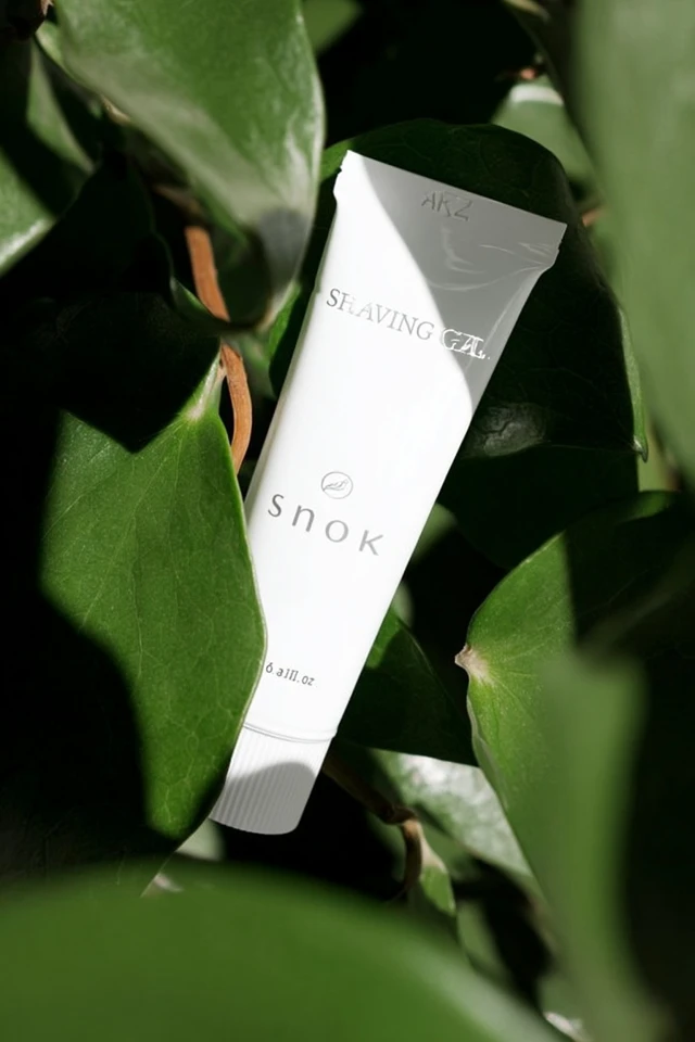 White Cosmetic Tube Surrounded by Leaves