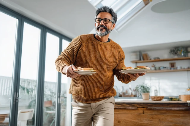 Cheerful Man Dancing with Breakfast in Kitchen