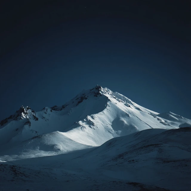 Snowy Mountain Peak Under a Dark Sky